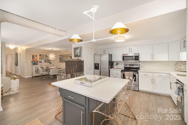 kitchen featuring appliances with stainless steel finishes, a breakfast bar, and white cabinets