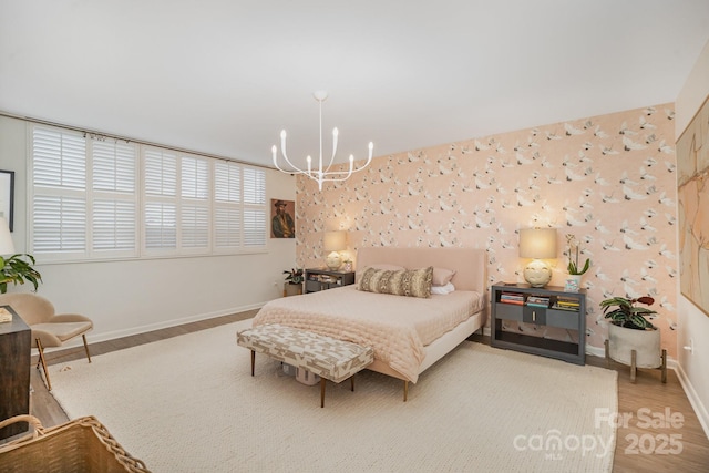 bedroom with wallpapered walls, baseboards, a chandelier, and wood finished floors