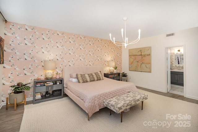 bedroom with wallpapered walls, baseboards, visible vents, and wood finished floors