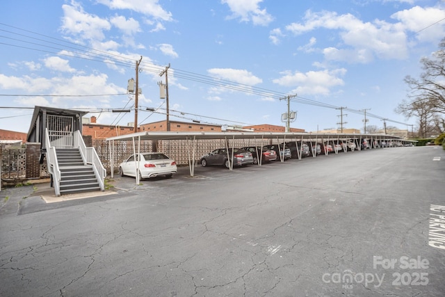 covered parking lot featuring stairway
