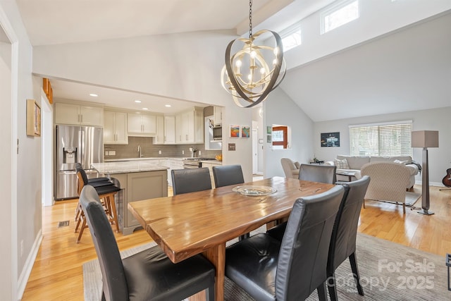 dining room with a chandelier, light wood-style flooring, and a healthy amount of sunlight