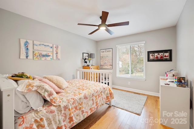 bedroom with light wood-type flooring, ceiling fan, and baseboards