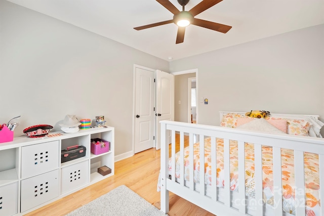 bedroom with light wood-style floors, ceiling fan, and baseboards