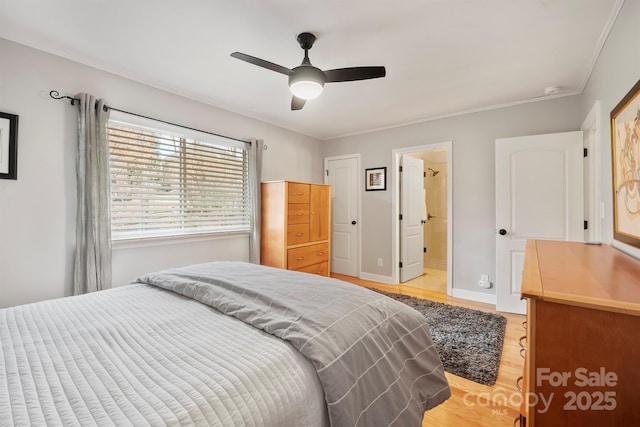 bedroom with crown molding, light wood finished floors, a ceiling fan, connected bathroom, and baseboards