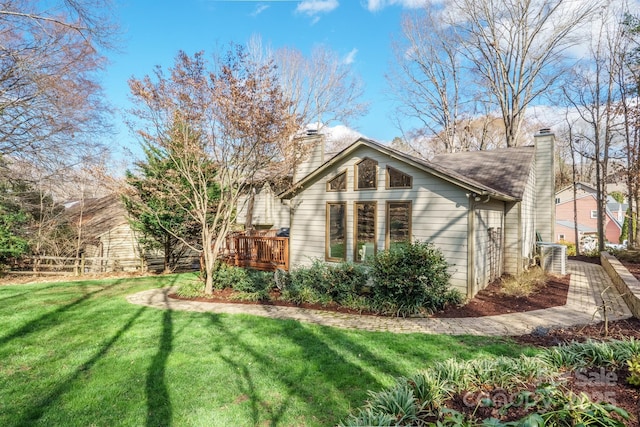 exterior space featuring a wooden deck, a chimney, and a yard