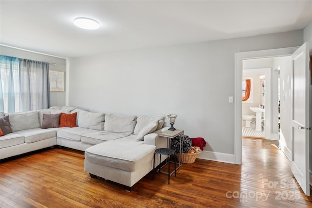 living area with hardwood / wood-style flooring and baseboards