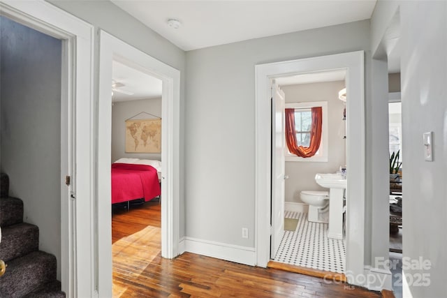 hall with stairs, hardwood / wood-style flooring, and baseboards
