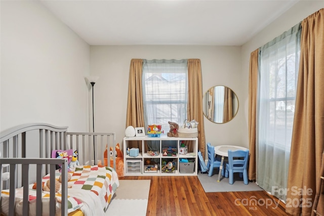 bedroom featuring multiple windows and wood finished floors