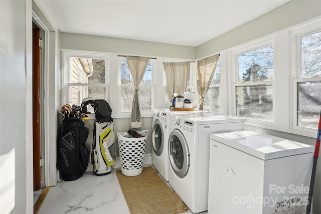 laundry area with laundry area, washer and clothes dryer, and a wealth of natural light