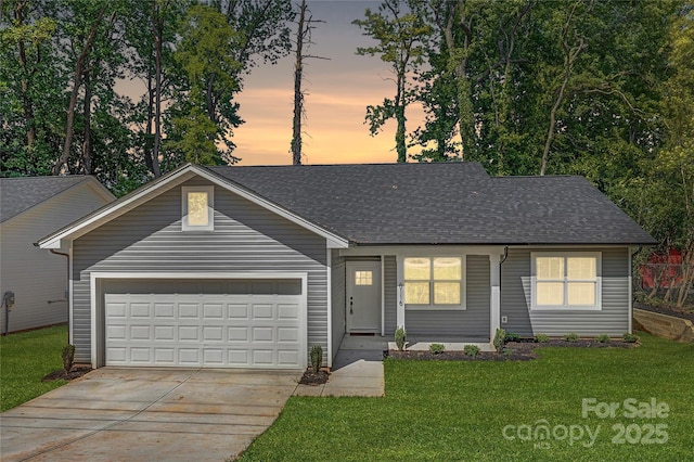 single story home with a garage, driveway, roof with shingles, and a yard