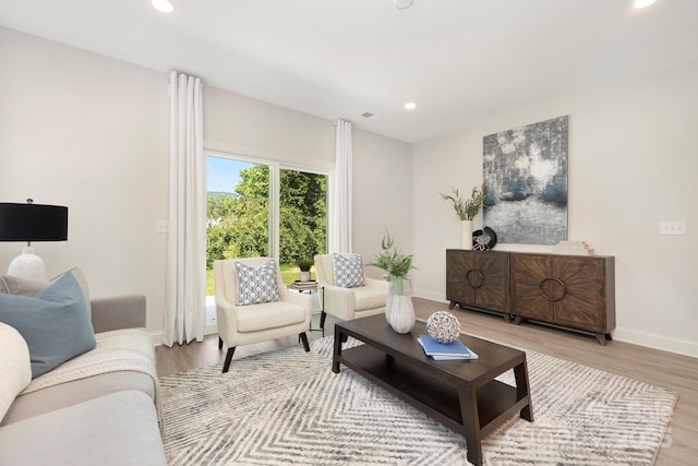 living room featuring baseboards, wood finished floors, and recessed lighting