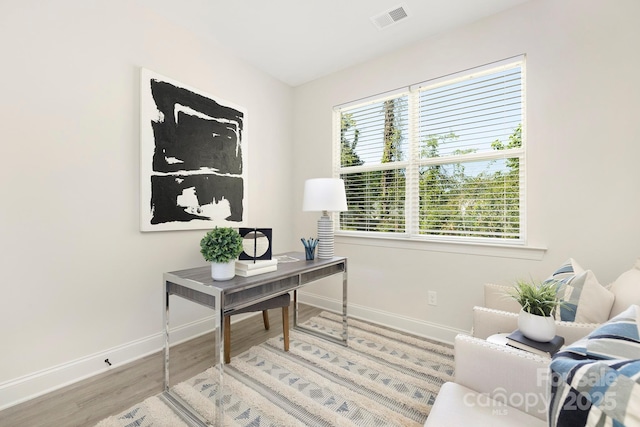 office area with baseboards, visible vents, and wood finished floors