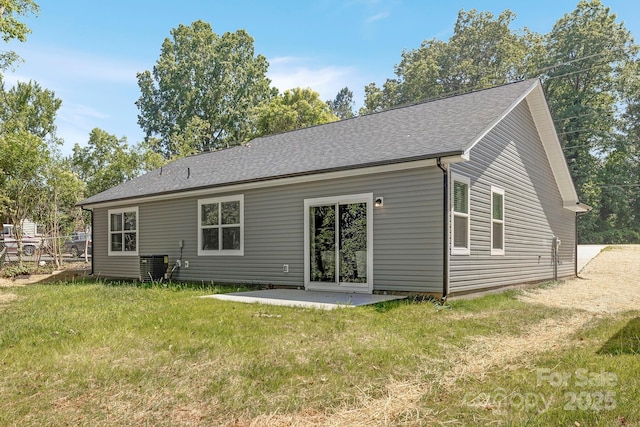 back of house featuring roof with shingles, central AC, a yard, and a patio