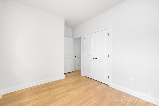 5404 Maplewood Ln, Charlotte, NC 28227 - unfurnished bedroom with light wood-type flooring, baseboards, and a closet
