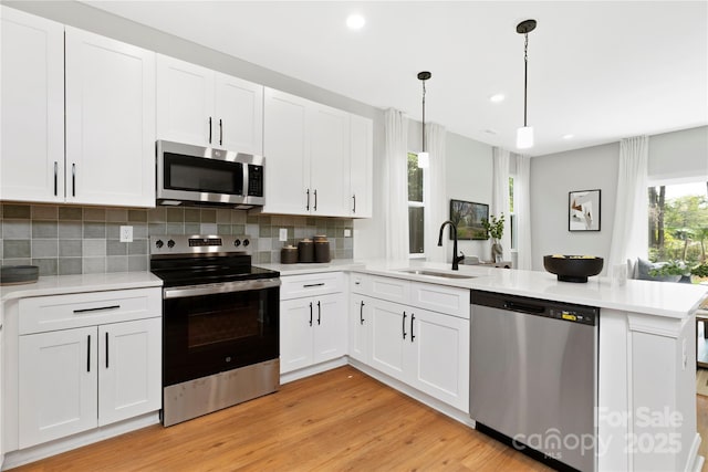 5404 Maplewood Ln, Charlotte, NC 28227 - kitchen featuring stainless steel appliances, a sink, a peninsula, light countertops, and backsplash