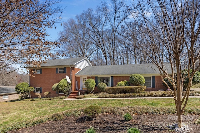 tri-level home with brick siding and a front lawn