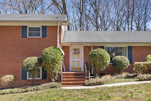 view of front of home with brick siding and a shingled roof