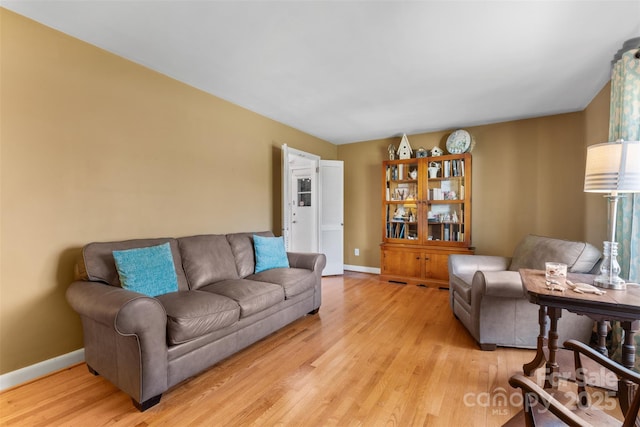 living room with baseboards and light wood-style flooring