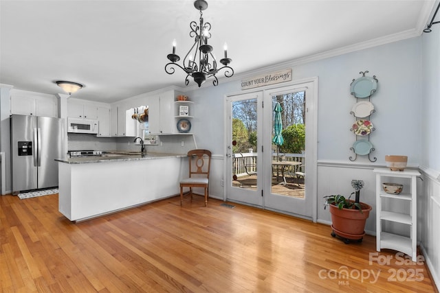 kitchen with open shelves, stainless steel appliances, light wood-style floors, and a peninsula