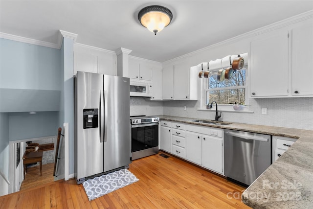 kitchen with a sink, stainless steel appliances, tasteful backsplash, and crown molding