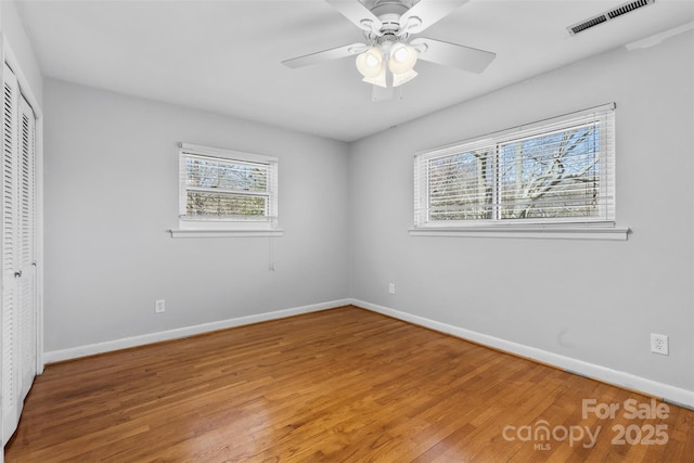 unfurnished bedroom featuring visible vents, ceiling fan, baseboards, light wood-style floors, and a closet