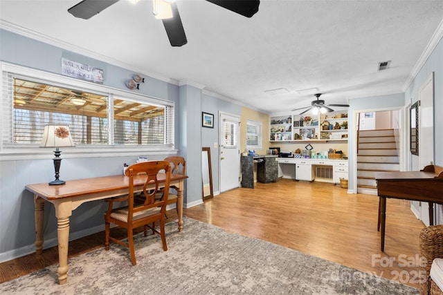 office featuring a healthy amount of sunlight, ornamental molding, and light wood finished floors