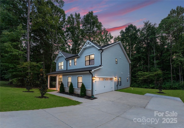 view of front facade featuring an attached garage, driveway, a front lawn, and brick siding