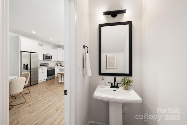 bathroom with recessed lighting and wood finished floors