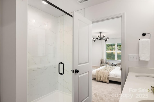 ensuite bathroom with a marble finish shower, visible vents, an inviting chandelier, ensuite bathroom, and a sink