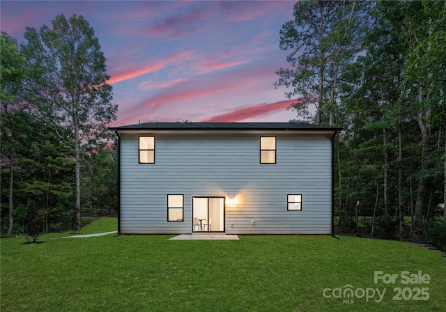 rear view of house featuring a patio area and a lawn