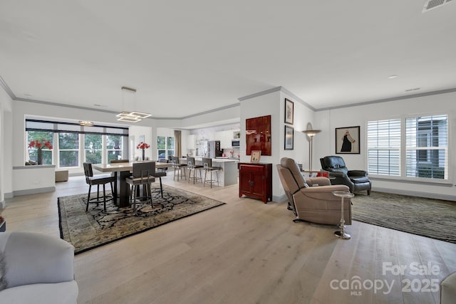 dining area with visible vents, plenty of natural light, light wood-style flooring, and crown molding