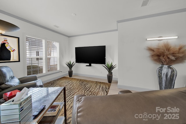 living room featuring visible vents, ornamental molding, and baseboards