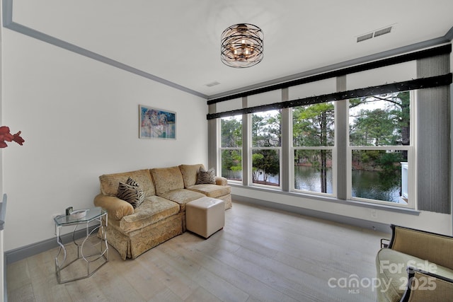 living area featuring a water view, light wood-style floors, baseboards, and visible vents