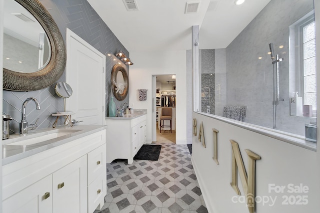 bathroom with two vanities, visible vents, and a sink