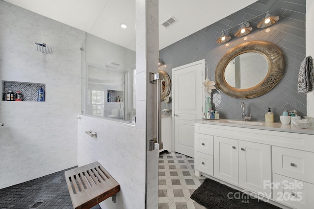 full bath featuring visible vents, tile walls, and vanity