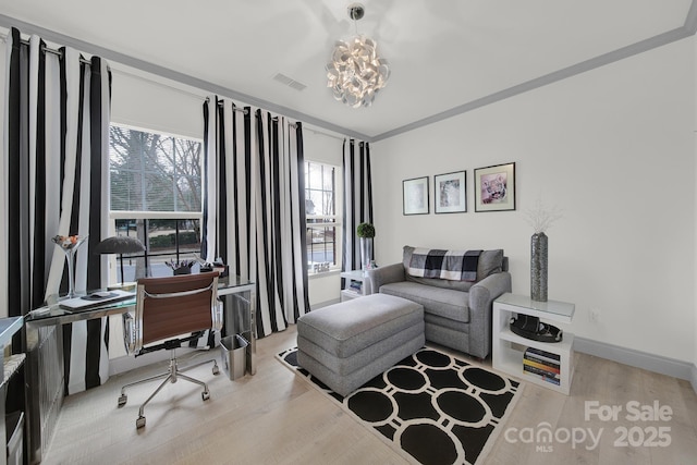 office with light wood-type flooring, visible vents, crown molding, and baseboards