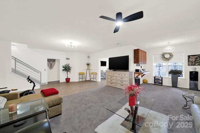 living room with carpet floors, ceiling fan, stairs, and baseboards