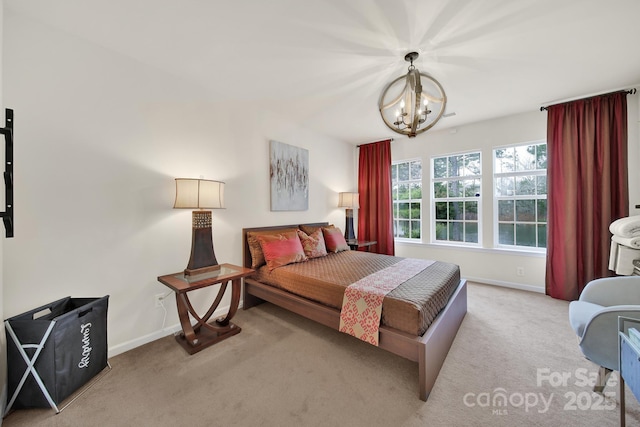 bedroom with light carpet, a notable chandelier, and baseboards