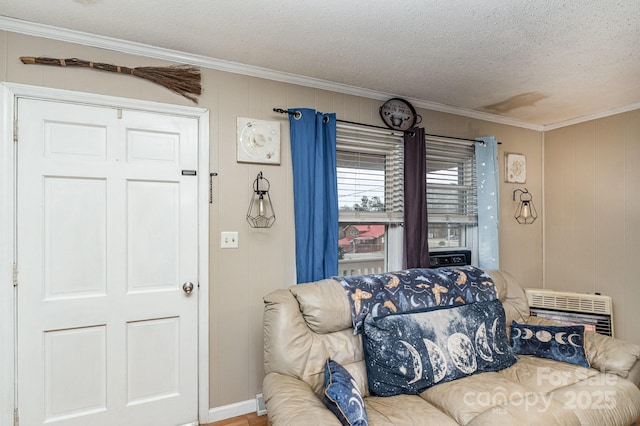 living area featuring a textured ceiling, ornamental molding, and heating unit