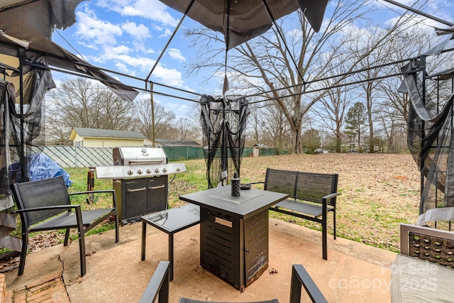 view of patio / terrace with a grill and fence