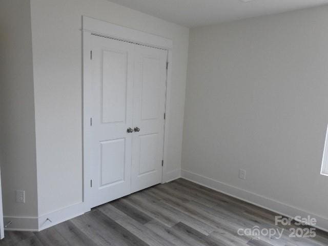 unfurnished bedroom featuring baseboards and wood finished floors