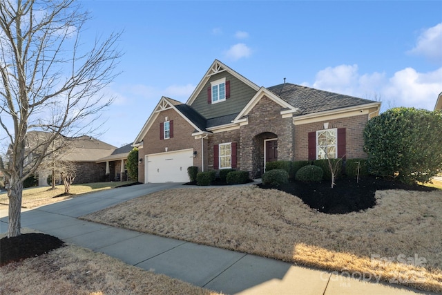 craftsman-style home with driveway, a garage, and brick siding