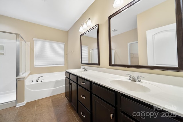 full bathroom featuring a stall shower, double vanity, a sink, and a bath