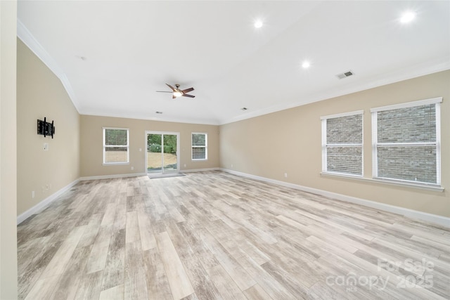 spare room with baseboards, light wood-style floors, visible vents, and crown molding