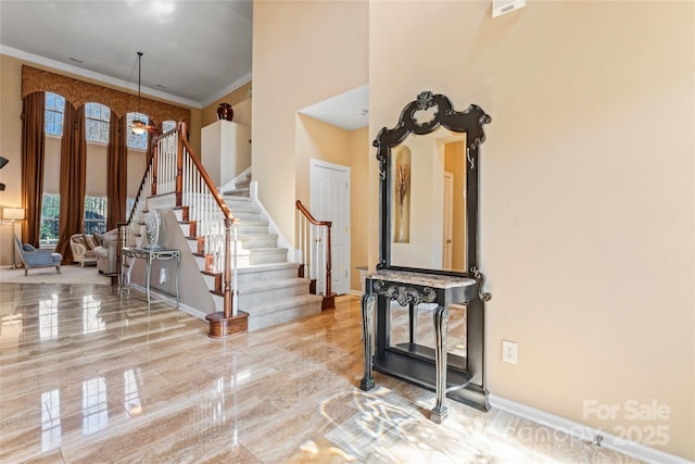 interior space with stairway, marble finish floor, crown molding, and a towering ceiling