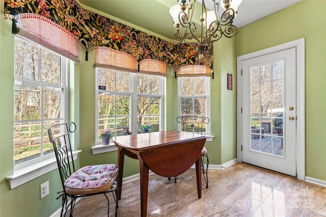 dining room with a notable chandelier and baseboards