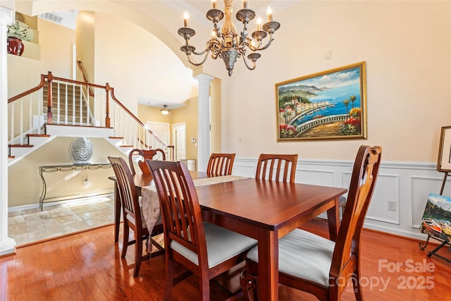 dining room featuring decorative columns, visible vents, stairway, and hardwood / wood-style floors