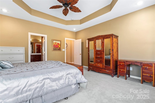 bedroom with a ceiling fan, a raised ceiling, light carpet, and baseboards