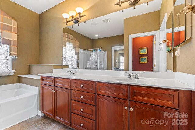 bathroom with double vanity, a sink, a shower stall, and a bath