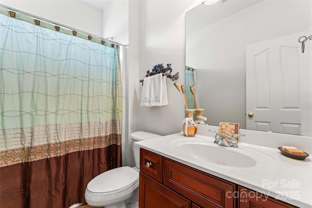 full bathroom featuring toilet, a shower with shower curtain, and vanity